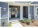 Covered front porch with stone accents, gray siding, and a black front door at 56 Braddock Ct, Garner, NC 27529