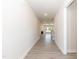 Long hallway showcasing modern gray floors leading to a living room with fireplace at 56 Braddock Ct, Garner, NC 27529