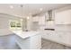 Well-lit kitchen with white cabinetry, stainless steel hood, and kitchen island seating at 56 Braddock Ct, Garner, NC 27529