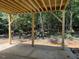 Covered patio with exposed wooden beams, overlooking a private, wooded backyard at 56 Braddock Ct, Garner, NC 27529