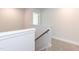 Bright stairway with carpet, neutral walls and a wooden railing at 56 Braddock Ct, Garner, NC 27529