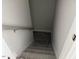 A stairwell leading downstairs, featuring white walls and railing, and carpeted stairs at 56 Braddock Ct, Garner, NC 27529