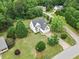 Aerial view of a white two-story home with a large lot in a wooded neighborhood at 5608 Scottish Hills Dr, Holly Springs, NC 27540