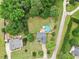Inviting aerial view of a home with a large backyard, pool, mature trees, and well-maintained landscaping at 5608 Scottish Hills Dr, Holly Springs, NC 27540