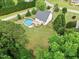 Aerial view of the house showing the above-ground pool, deck, and the surrounding greenery of the property at 5608 Scottish Hills Dr, Holly Springs, NC 27540