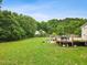 Sprawling backyard with a verdant lawn, complemented by a deck and a swimming pool, ideal for outdoor activities at 5608 Scottish Hills Dr, Holly Springs, NC 27540