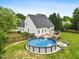 Expansive backyard featuring a pool, deck, and lush green lawn extending from the rear of the home at 5608 Scottish Hills Dr, Holly Springs, NC 27540