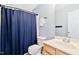 Cozy bathroom with a vanity, commode, and a shower and tub enclosed by a blue shower curtain at 5608 Scottish Hills Dr, Holly Springs, NC 27540