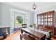 Elegant dining room with wooden floors, table and chairs set beside a bay window at 5608 Scottish Hills Dr, Holly Springs, NC 27540