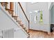 Bright foyer with hardwood floors, wooden staircase, and a clear view of the front door at 5608 Scottish Hills Dr, Holly Springs, NC 27540