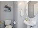 Charming powder room featuring a pedestal sink, toilet, and decorative mirror at 5608 Scottish Hills Dr, Holly Springs, NC 27540