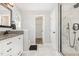 Bathroom featuring a glass shower, granite-topped vanity with drawers, and elegant lighting at 5637 Yates Garden Ln, Raleigh, NC 27606