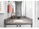 Half bathroom vanity with granite countertop, white cabinetry, and modern fixtures at 5637 Yates Garden Ln, Raleigh, NC 27606