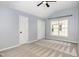 Bright bedroom featuring a vaulted ceiling, large window, and neutral-toned carpet at 5637 Yates Garden Ln, Raleigh, NC 27606