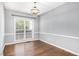 Dining room with hardwood floors, chandelier, and a large window providing natural light at 5637 Yates Garden Ln, Raleigh, NC 27606