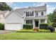 Inviting two-story home with manicured landscaping, a covered porch and an attached garage at 5637 Yates Garden Ln, Raleigh, NC 27606
