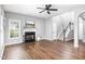 Spacious living room featuring a fireplace, hardwood floors, and an open staircase at 5637 Yates Garden Ln, Raleigh, NC 27606