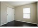 Bedroom with sliding barn doors, window, wood-look floors, and neutral walls at 6101 Ricker Rd, Raleigh, NC 27610