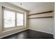 Neutral bedroom with two windows, built-in shelving, and wood-look floors at 6101 Ricker Rd, Raleigh, NC 27610