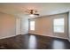 Spacious bedroom with dark laminate floors, ceiling fan, and two windows for natural light at 6101 Ricker Rd, Raleigh, NC 27610