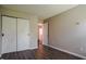 Bedroom with sliding barn doors, neutral walls, and wood-look floors at 6101 Ricker Rd, Raleigh, NC 27610