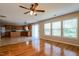 Bright living room with hardwood floors, ceiling fan, and sliding glass doors to the backyard at 6101 Ricker Rd, Raleigh, NC 27610