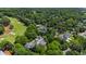 Beautiful aerial view of estate home surrounded by lush landscaping and a golf course in the background at 6510 New Market Way, Raleigh, NC 27615