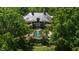 Aerial view showing a gorgeous estate home and sparkling pool surrounded by trees at 6510 New Market Way, Raleigh, NC 27615