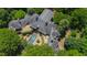 Aerial view showcases an estate-style home with an in-ground pool, manicured landscaping, and stone patio at 6510 New Market Way, Raleigh, NC 27615