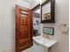 Cozy bathroom with wooden door and sink with a brass faucet at 6510 New Market Way, Raleigh, NC 27615