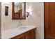 Powder room with a marble countertop, wooden cabinets, and detailed wall lighting at 6510 New Market Way, Raleigh, NC 27615