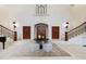 Elegant foyer with grand staircase, wooden doors, and stylish decor create a welcoming entrance at 6510 New Market Way, Raleigh, NC 27615