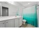 Bright bathroom featuring a large mirror over the vanity and a shower with a teal shower curtain at 68 Holly Berry Ln, Durham, NC 27703