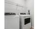 Practical laundry area with modern washer, dryer, and storage shelf for convenience at 68 Holly Berry Ln, Durham, NC 27703