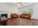 Spacious living room with fireplace, ceiling fan, and comfortable leather seating at 68 Holly Berry Ln, Durham, NC 27703