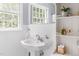 Close-up of bathroom showcasing pedestal sink, white wainscoting, and built-in shelves at 816 Miller Rd, Hillsborough, NC 27278