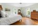 Bright bedroom featuring hardwood floors, two windows, and classic wooden furniture at 816 Miller Rd, Hillsborough, NC 27278