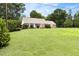 Well-maintained front yard showcases a charming single-story home with lush green lawn and mature trees at 816 Miller Rd, Hillsborough, NC 27278