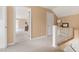 Hallway with neutral carpeting leading to open spaces, featuring a staircase at 816 Miller Rd, Hillsborough, NC 27278