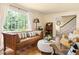 Cozy living room featuring a leather sofa, large window and hardwood floors at 816 Miller Rd, Hillsborough, NC 27278