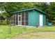 Charming green outbuilding surrounded by flowers and greenery in a landscaped backyard at 816 Miller Rd, Hillsborough, NC 27278