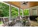 Relaxing back porch with ceiling fan, multiple seating areas, and wooded scenery for outdoor living at 8405 Hempton Cross Dr, Wake Forest, NC 27587