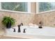 A luxurious soaking tub with bronze fixtures and decorative tile surround accents this home at 8405 Hempton Cross Dr, Wake Forest, NC 27587