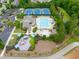 Aerial view of the tennis courts, pool and clubhouse in a wooded setting at 8405 Hempton Cross Dr, Wake Forest, NC 27587