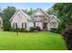 Charming brick and stone home with manicured landscaping, a well-maintained lawn, and mature trees at 8405 Hempton Cross Dr, Wake Forest, NC 27587