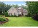 Brick and stone front elevation with shutters, dormers, and a neatly landscaped front yard at 8405 Hempton Cross Dr, Wake Forest, NC 27587