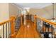 Bright hallway featuring hardwood floors, iron railing, and natural light at 8405 Hempton Cross Dr, Wake Forest, NC 27587