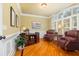 Bright home office with rich wood floors, wainscoting, and cozy leather chairs create a professional work space at 8405 Hempton Cross Dr, Wake Forest, NC 27587