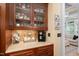 Elegant butler's pantry area with custom cabinetry, granite countertops, and a coffee station at 8405 Hempton Cross Dr, Wake Forest, NC 27587