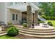 Covered patio featuring stone columns, a dining area, and an outdoor fire pit on a multi-tiered patio at 8405 Hempton Cross Dr, Wake Forest, NC 27587